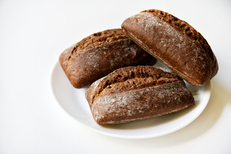 Rye bread from a hypermarket on a white plate. Delicious and beautiful bread macrophoto.の写真素材