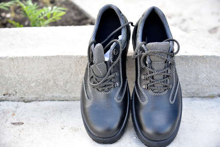 Black new work boots on the street during the day.Vintage design style. modern design.の写真素材