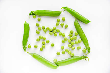 Pods of fresh green peas and green scattered peas. nature background. design element.の写真素材