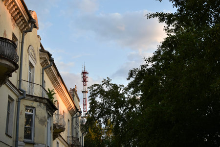 Yellow building in the city in the evening and evening sky with clouds. Beautiful sunset and a house...