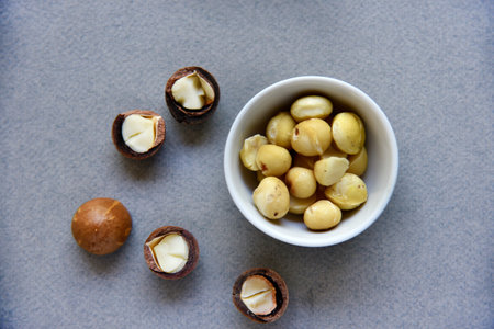 Delicious peeled Macadamia nut in a salad bowl on a gray background. The kernels of a delicious...