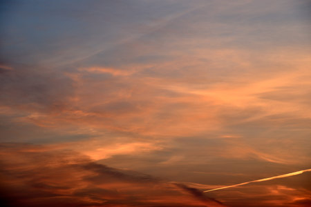 Beautiful sunset light and clouds and a trace of the plane. Evening sunset landscape in summer.