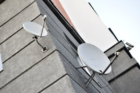 Satellite dish on a gray building close-up. A parabolic antenna on the wall. science technology.の写真素材