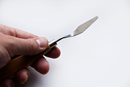 Palette knife no. 4 artistic iron with a wooden handle on a white background. An artist's paint tool. school education.の写真素材