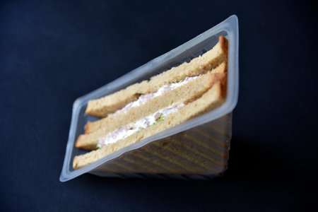 Delicious sandwiches in plastic packaging close-up on a black background. Delicious breakfast in a package.の写真素材