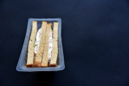 Delicious sandwiches in plastic packaging close-up on a black background. Delicious breakfast in a package.の写真素材