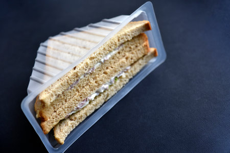 Delicious sandwiches in plastic packaging close-up on a black background. Delicious breakfast in a package.の写真素材