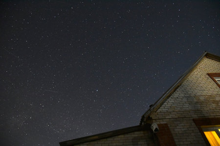 The starry sky and the roofs of houses. Astrophotography in a village with houses. nature summer. green house.の写真素材