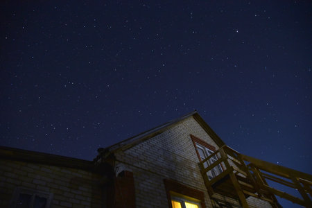 The starry sky and the roofs of houses. Astrophotography in a village with houses. nature summer....