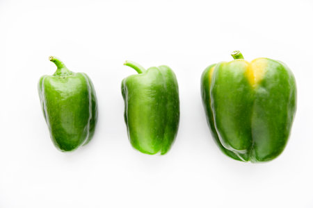 Juicy green and yellow pepper fruits on a white background. Beautiful shiny and delicious pepper....