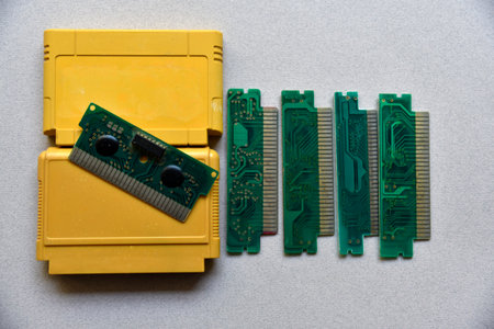 Electronic cartridge board for retro game console. A yellow plastic cartridge on a black background and an electronic board.Digital technology concept. Black background. modern design.の写真素材