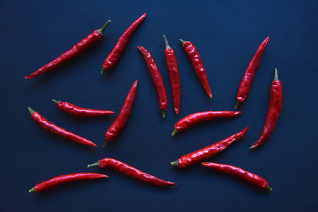 Red hot capsicum on a black background. Spice close-up. Capsicum in a group on the background. Vegetarian food. green natural background. traditional indian food. healthy eating.の写真素材