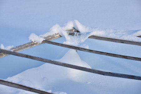 Wooden boxes in winter in the snow. A small greenhouse in snowdrifts in winter.Farming agriculture...