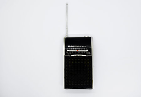 Portable radio receiver on a white background. Small player close-up. A battery-powered radio.