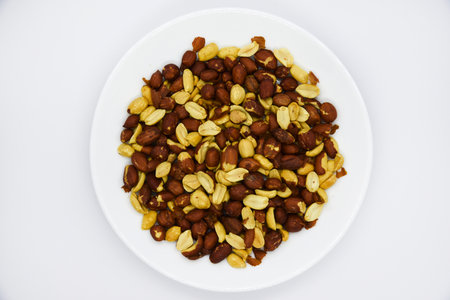 Peeled peanut kernels on a white plate. Delicious nuts. Peeled peanuts.の写真素材