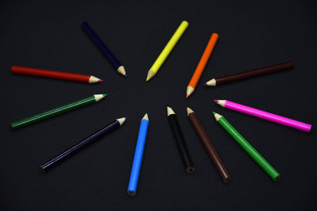 Colored pencils on a black background. Small pencils close-up.の写真素材
