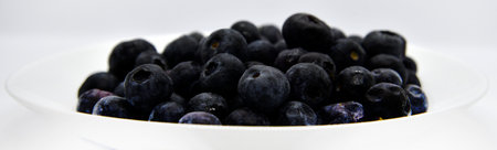 Delicious and juicy blueberries on a white plate on a white background. Large blueberry yayagods.の写真素材