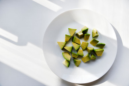 Avocado cut into small slices. avocado salad. Peeled avocado on a plate.の写真素材