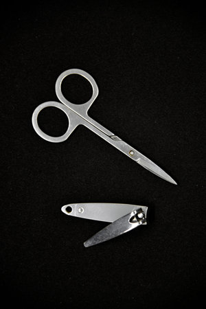 Manicure set on a black background. Scissors and nail tongs. Iron scissors and nail clippers.
