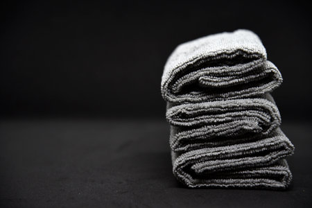 Three gray towels on a black background. Terry cloths for wiping furniture. Towels on a black background.の写真素材