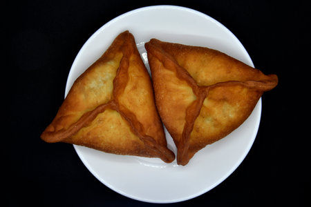 Meat pies on a white plate. Belyashi. Delicious meat pies on a black background.の写真素材