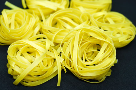 Dry paste on a black background. Wheat pasta.