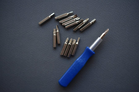 A set of metal screwdrivers on a dark background. top view.
