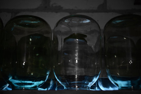 Empty glass bottles on the shelf in the dark room. close up.の写真素材