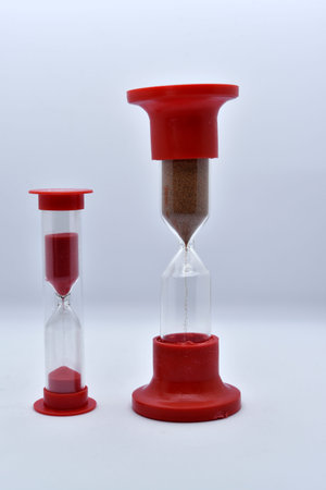 Glass hourglass on a white background. Multicolored glass hourglass.