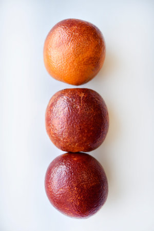 Red oranges on a white background. Juicy fruits. Bright and juicy oranges.