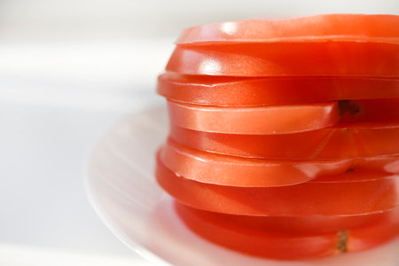 Chopped tomato on a white plate. tomato salad. sliced vegetables. red tomatoes.の写真素材