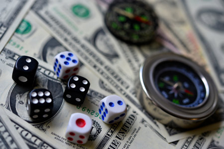 Dice, compass and dices on a background of dollar billsの写真素材