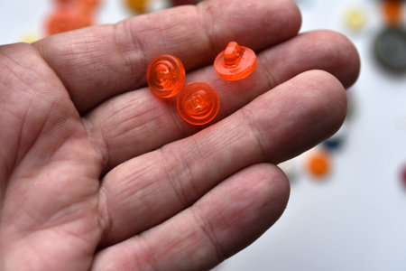 Round red buttons in the hand. Round buttons from clothes.の写真素材