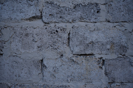 A gray wall of large blocks. Gray cinderblock. The wall of an industrial building.の写真素材
