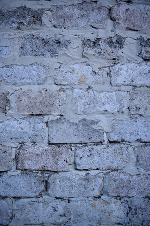 A gray wall of large blocks. Gray cinderblock. The wall of an industrial building.
