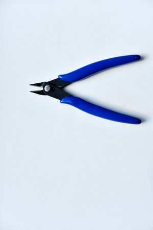 Forceps with a blue handle on a white background. A tool for repairing electronics.の写真素材