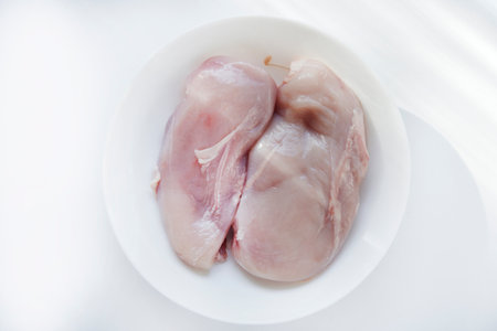 Pieces of chicken fillet in a white cup. Fresh chicken meat in chunks.の写真素材