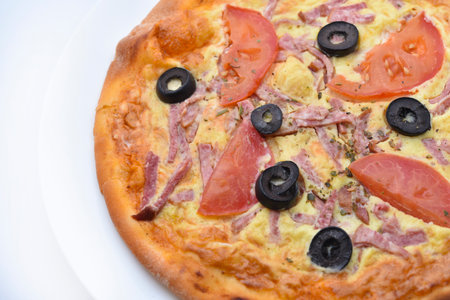 Meat round pizza with olives on a white plate. Italian flatbread.の写真素材