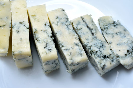 Sliced cheese with blue mold on a white plate. Delicious breakfast with cheese.の写真素材