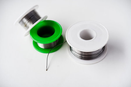 Tin-lead solder in coils on a white background. Materials for soldering.の写真素材