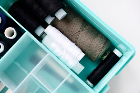 A set of colorful sewing threads. Skeins of thread in a plastic box.