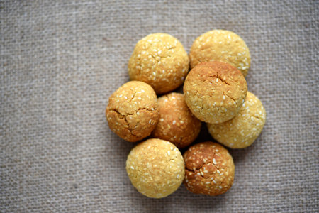 A pile of sesame cookies on a burlap bag. Sweet sugar yellow cookies.