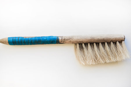 An old brush with a wooden handle on a white background. An old detail.の写真素材