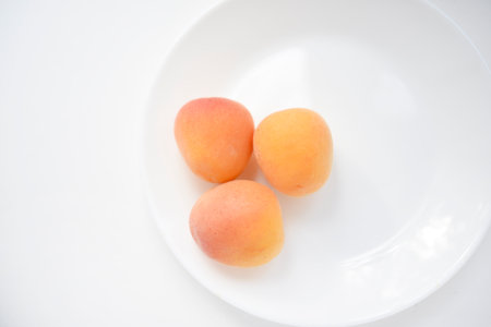 Yellow plums on a white plate. Fresh fruits.の写真素材
