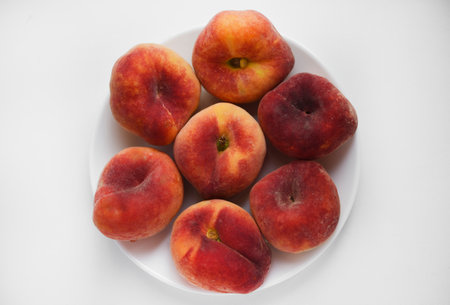 Flat peaches on a white background. Peaches in a package.の写真素材