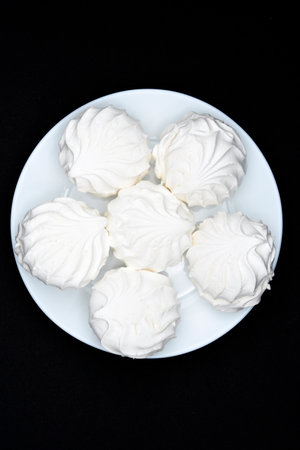 Marshmallows on a white plate. Sweet white marshmallows in round slices.の写真素材