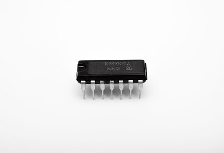 An old chip on a white background. The chip is in a DIP case. An integrated circuit.