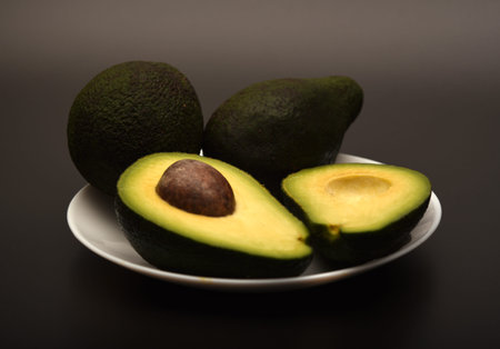 Avocado on a gray background. Avocado on a plate.