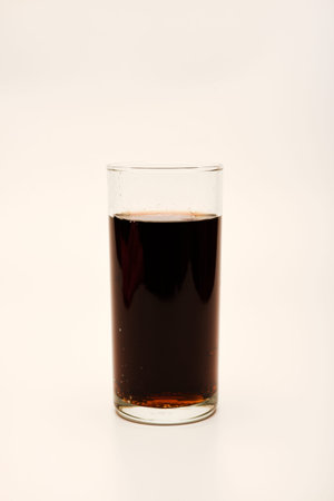 A glass glass with soda on a white background. Juice in a glass.