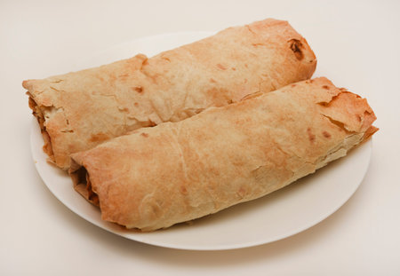 Meat shawarma on a white plate. Burritos with meat.
